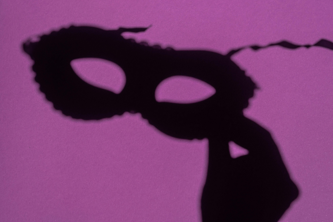 Shadow of a masquerade mask with a purple background