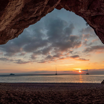 Sunset over the ocean viewed from a rocky cave entrance