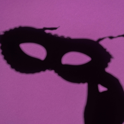 Black mask silhouette on a purple background
