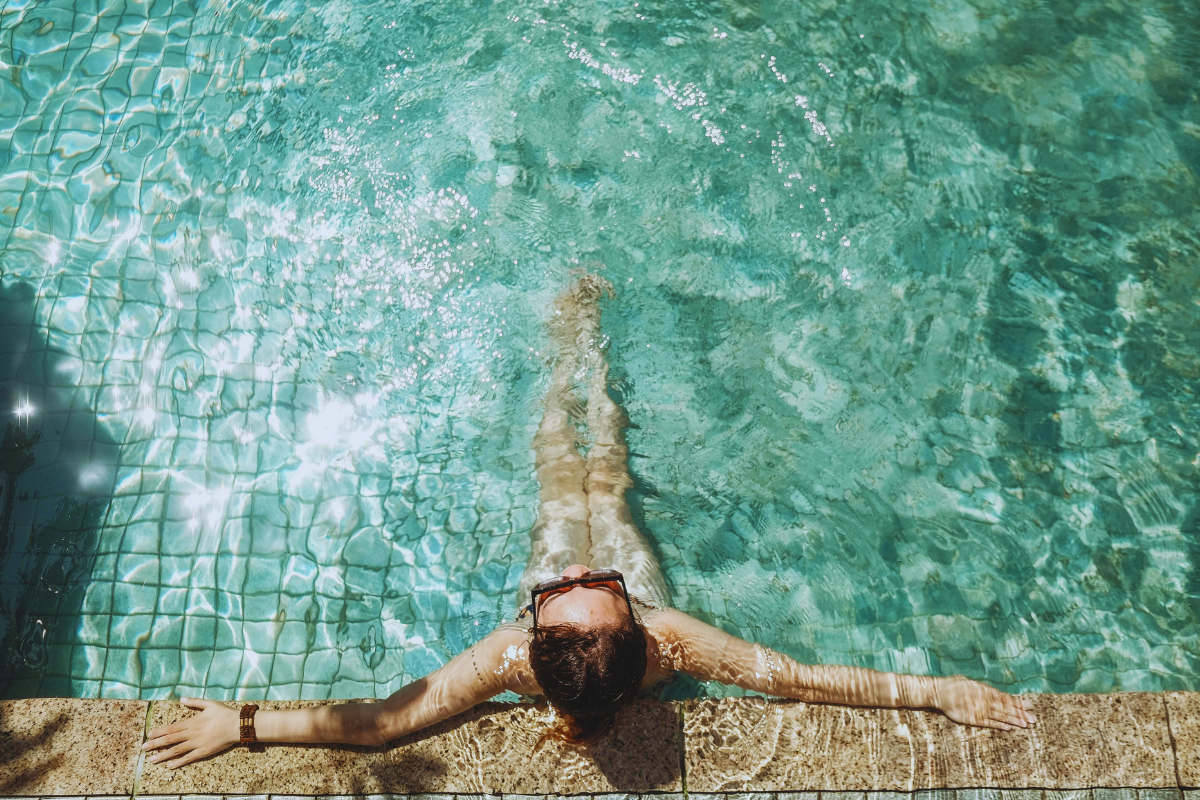 Woman Wearing Sunglasses Sitting Poolside